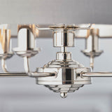 Close-up of the Endon Brenley V2 6 Light Pendant showing the polished nickel hub, tiered finial, and arms with candle-style holders beneath a grey shade.