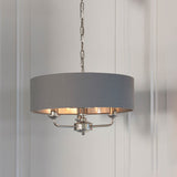 Endon Brenley V1 3 light pendant with grey linen drum shade, brushed metallic inner lining, and polished nickel arms, suspended on a chain.