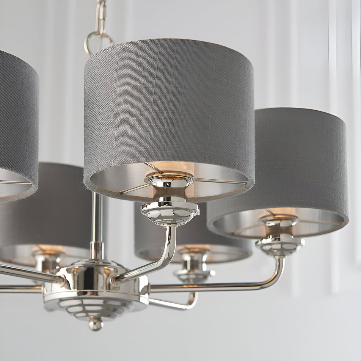 Close-up of the Endon Brenley six-light pendant showing polished nickel arms and charcoal grey linen shades with brushed metallic inner linings.