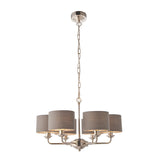 Endon Brenley V3 six-light pendant shown with fewer grey linen drum shades on nickel arms, hanging from a chain, on a white background.