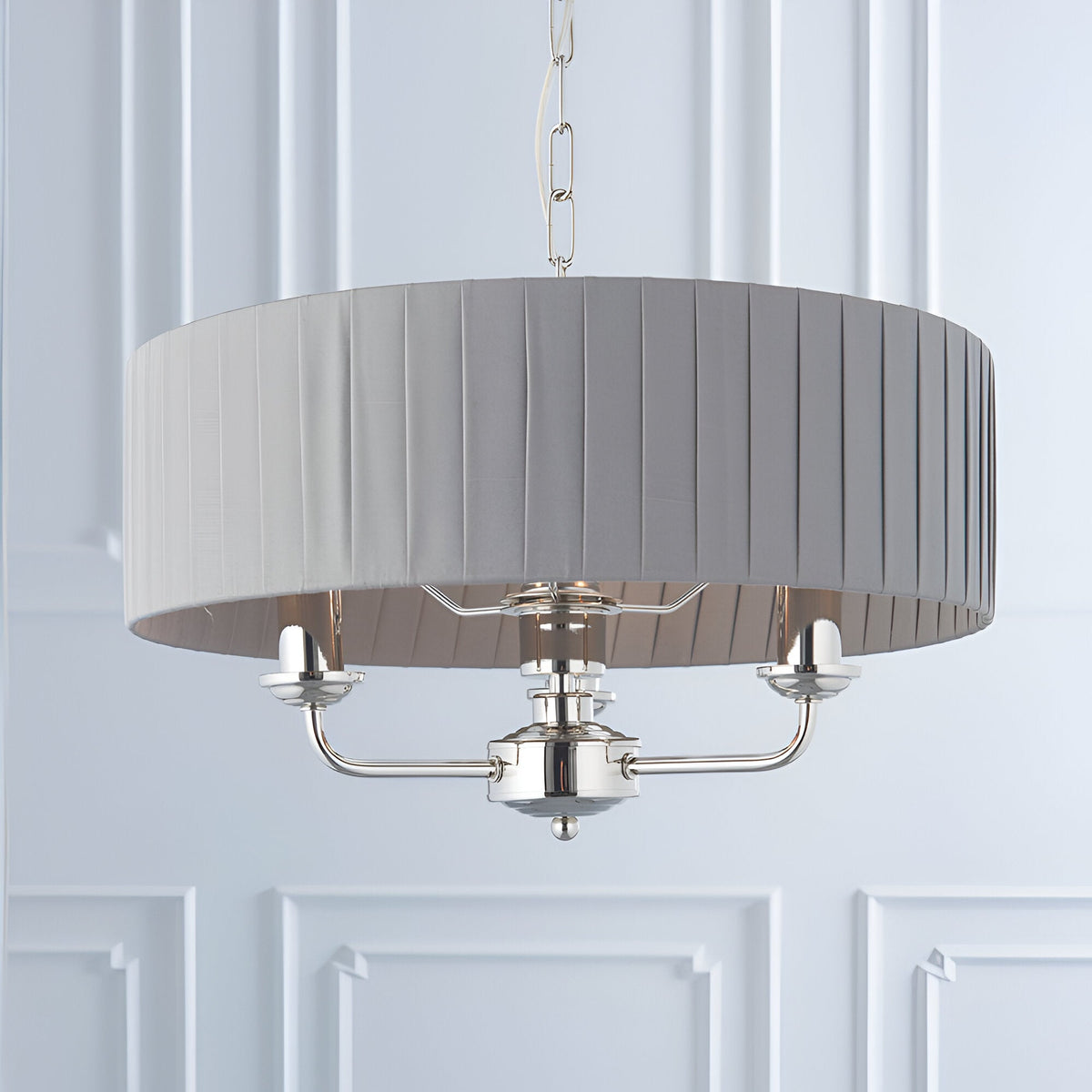 Brenley V2 3-light pendant in nickel with a grey pleated fabric drum shade, three candle-style arms, and chain suspension.