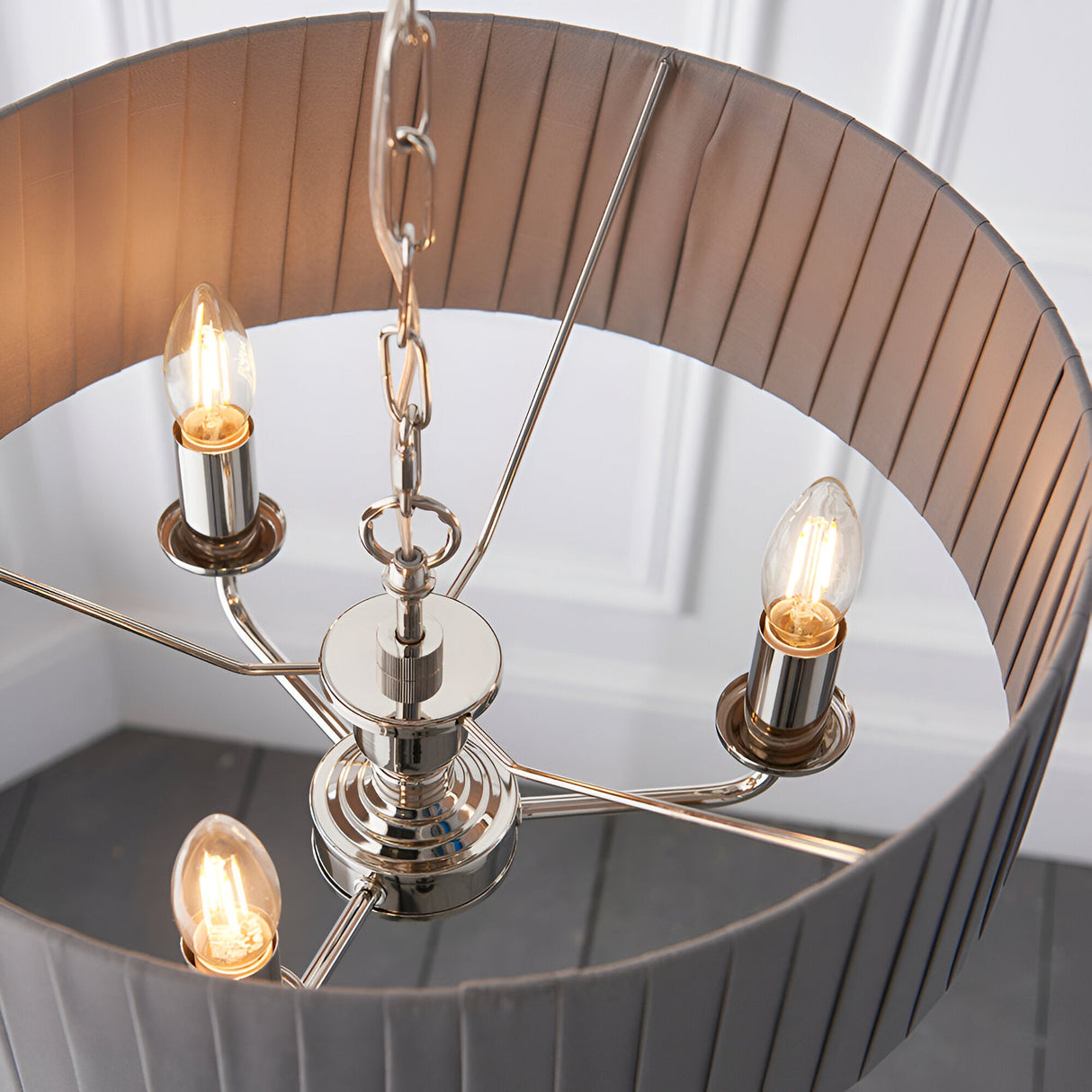 Brenley V2 3 Light Pendant in nickel, showing three candle-style E14 bulbs on metal arms beneath a pleated grey fabric shade with mirrored inner lining.