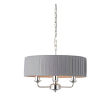 Brenley V2 3 Light Pendant in nickel with a pleated grey fabric drum shade, three exposed candle-style arms, and a chain suspension on a plain white background.