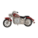 Miniature Indian-style motorbike mantel clock in red metal alloy with silver-tone engine, forks and spoked wheels, black seat and tyres, quartz clock face set into the engine, on a white background.