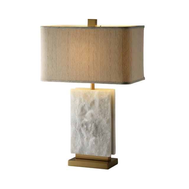 The Axis 1 Light Alabaster Table Lamp features a brass finish, soft white alabaster, a rectangular beige fabric shade, a white marble base, and gold accents, shown against a plain white background.
