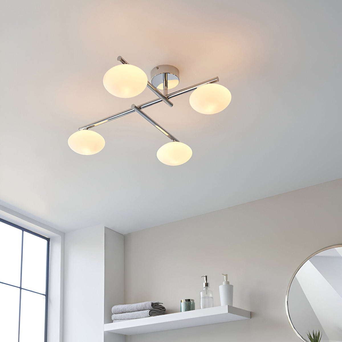 Denby 4 Light Semi-Flush Bathroom Ceiling Light in chrome, with crossed arms and four opal glass shades, shown on a white ceiling above a bathroom shelf.