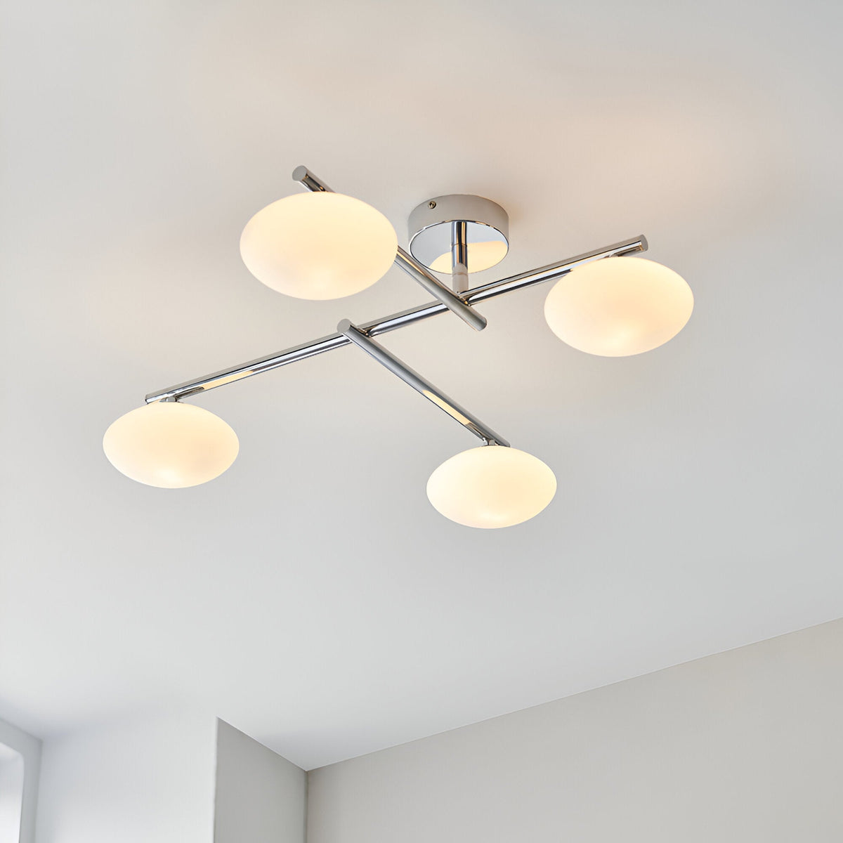 Denby 4 light semi-flush bathroom ceiling light in chrome, four opal glass globe shades on angled arms, mounted on a light ceiling.