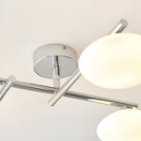 Close-up of the Denby 4-light semi-flush bathroom ceiling light in chrome, showing the circular ceiling plate, angled arms, and opal glass globe shades.
