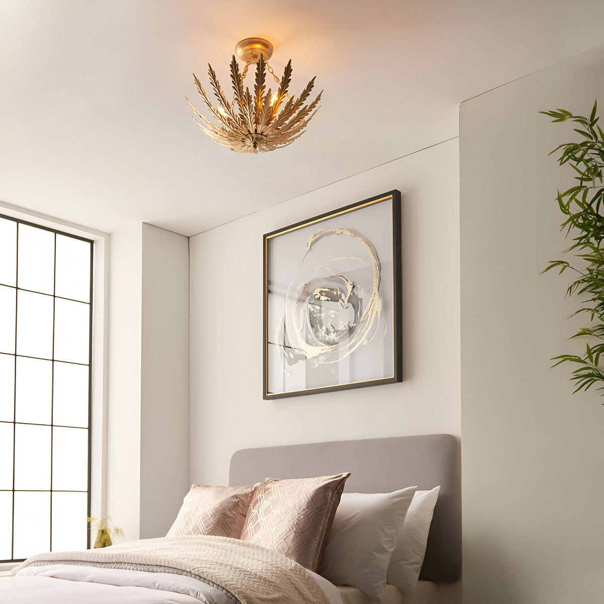 Endon Colette 3 light flush ceiling light in gold with layered metal leaf design, installed in a bedroom above a grey headboard and framed artwork.