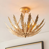 Endon Colette 3 light flush ceiling light in gold, with layered metal leaf arms radiating from a central chain-suspended frame, mounted to a white ceiling.