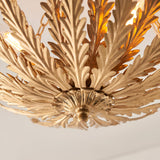Close-up of Endon Colette 3 Light Flush Ceiling Light in gold, showing layered metal leaf detailing around the central mount with lit E14 lamps above.