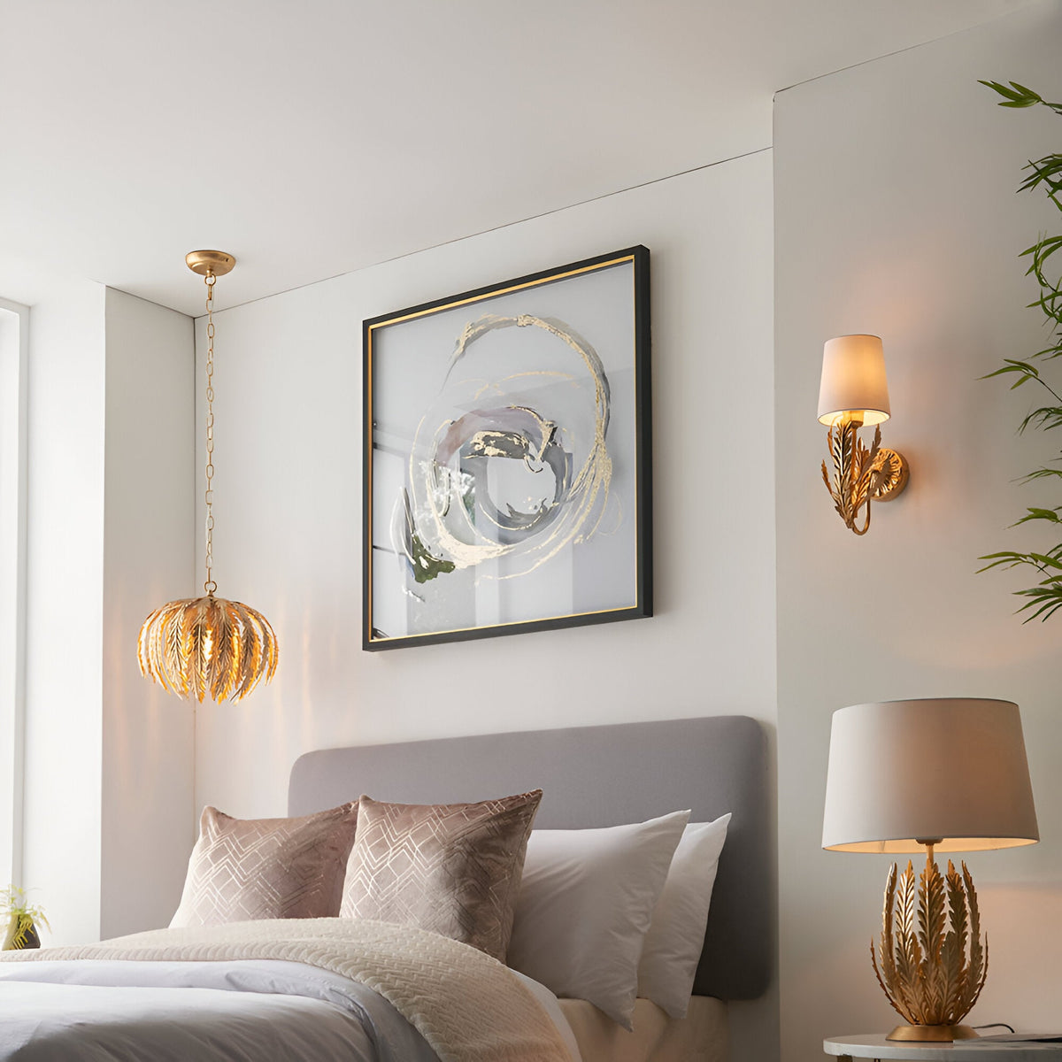 Colette Wall Light in gold leaf finish with layered leaf design and cream fabric shade, shown illuminated beside a bedroom wall.