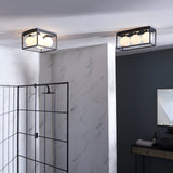 Endon Sable 4 light semi-flush bathroom ceiling lights in matt black with glass globe shades, shown installed in a marble-tiled bathroom.