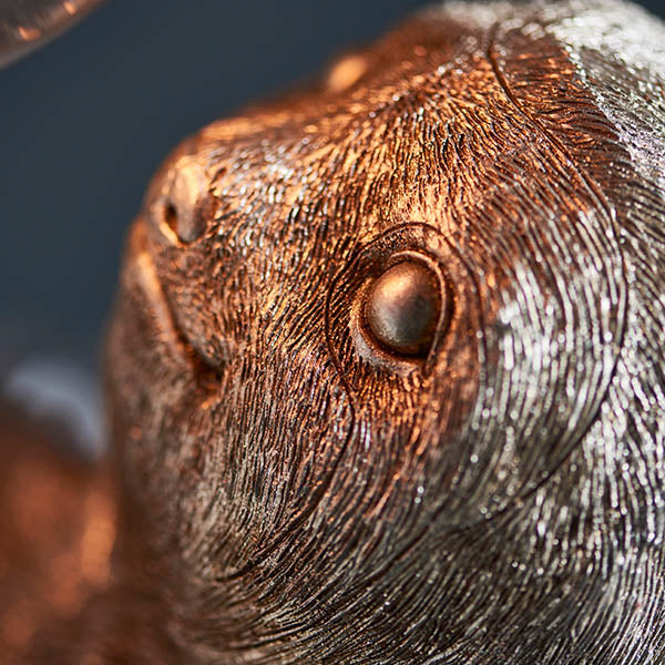 Close-up of Endon Cliffmont table lamp showing the resin sloth's face and eye in vintage silver finish with fine moulded fur detail.