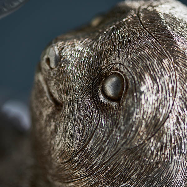 Close-up of the Endon Cliffmont table lamp showing the detailed resin sloth's face and textured fur in a vintage silver finish.