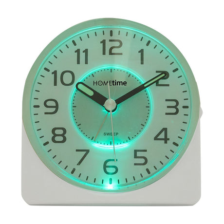 Silent Sweep round face alarm clock in a white arched plastic case, glowing green on the illuminated dial with black numerals and sweep hands, shown on a plain white background.