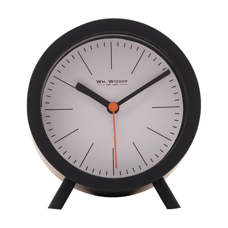 Round plastic alarm clock in matt black with a white dial, black hour markers, black hands, orange sweep second hand, and two slim feet, on a plain white background.