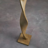 Endon Alcott floor lamp base detail showing the light oak effect spiral wood column on a square plinth against a grey floor.