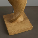 Alcott Table Lamp base close-up in light oak-effect wood with a spiral twist, set on a square wooden platform against a neutral background.