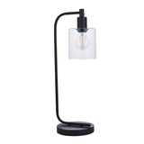 Endon Cranmere table lamp in matt black metal with an arched arm and clear glass cylinder shade around a visible filament bulb, on a plain background.