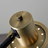 Close-up of the Carlbourne Floor Lamp's brass shade head with knurled rotary switch and black adjustable bracket, industrial style, on a plain grey background.