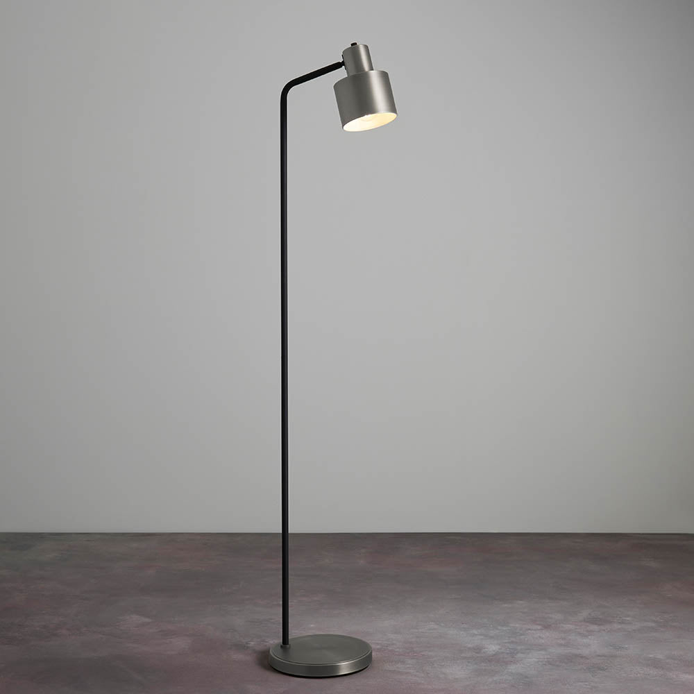 Endon Carlbourne industrial floor lamp with brushed silver cylindrical shade, matt black stem and silver disc base, shown against a plain light grey backdrop.
