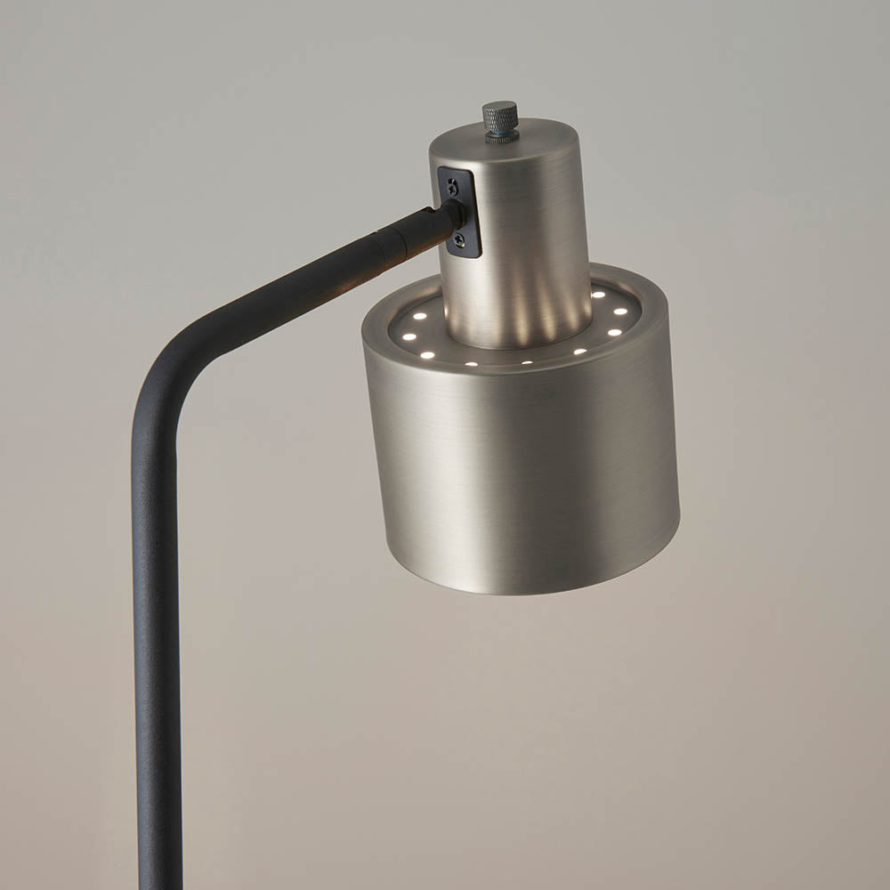 Endon Carlbourne floor lamp head close-up in brushed silver and matt black, showing the cylindrical shade, knurled fitting, and industrial styling.