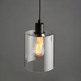 Endon Cranmere pendant light in matt black with a compact clear glass cylinder shade and lit E27 filament bulb, shown against a grey background.