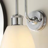 Chartdon Bathroom Wall Light in polished chrome with a swan-neck arm, knurled ring detail, and gloss opal glass shade, mounted on a neutral wall.