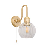 Endon Brockshaw bathroom wall light in satin brass with swan-neck arm, ribbed clear glass globe shade, and pull-cord switch on a plain background.