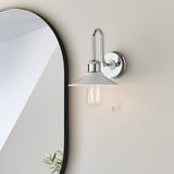 Cardew Bathroom Wall Light in polished chrome with a swan-neck arm, gloss white coolie shade, exposed bulb and pull switch, mounted beside a bathroom mirror.