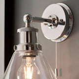 Close-up of Endon Cranmore bathroom wall light in chrome, showing knurled back plate, pull cord switch and cone-shaped clear glass shade with E27 bulb.