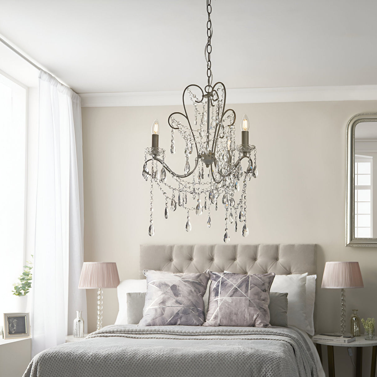 Endon Aldwood 3 light pendant in aged silver with faceted crystal droplets, hanging above an upholstered bed in a neutral bedroom setting.