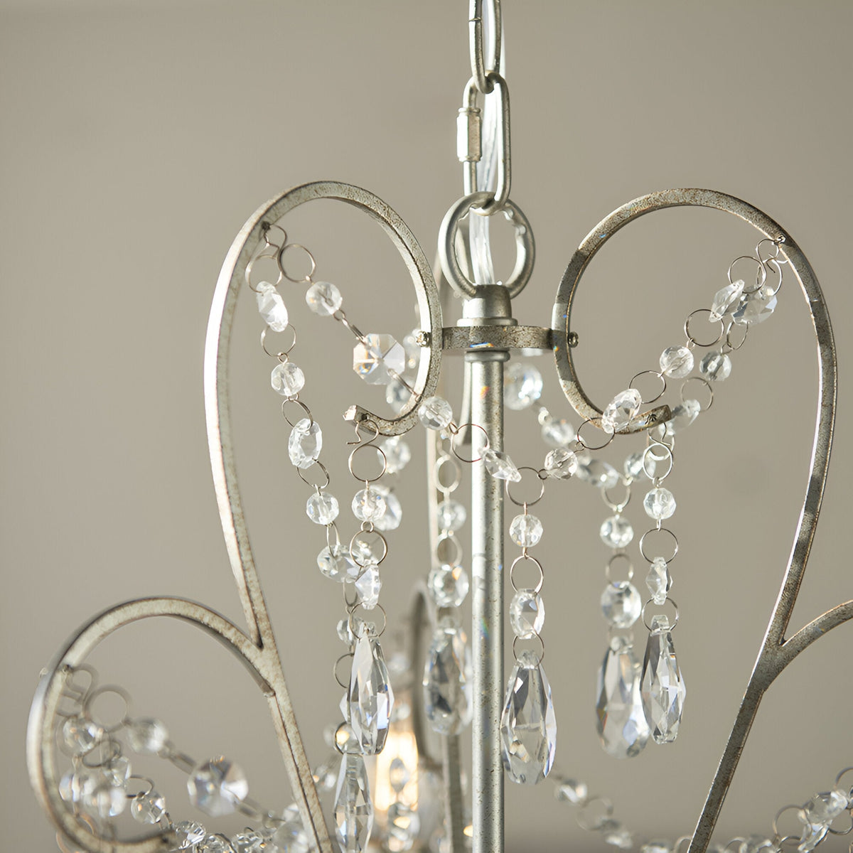 Close-up of Endon Aldwood 3 light pendant showing aged silver scrolled metal frame, chain suspension and clear faceted crystal glass droplets.