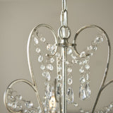 Close-up of Endon Aldwood 3 light pendant showing aged silver scrolled metal frame, chain suspension and clear faceted crystal glass droplets.