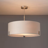 Endon Brendon 3 Light Pendant in satin nickel with a large white fabric drum shade and internal diffuser, mounted to a ceiling against a grey wall.