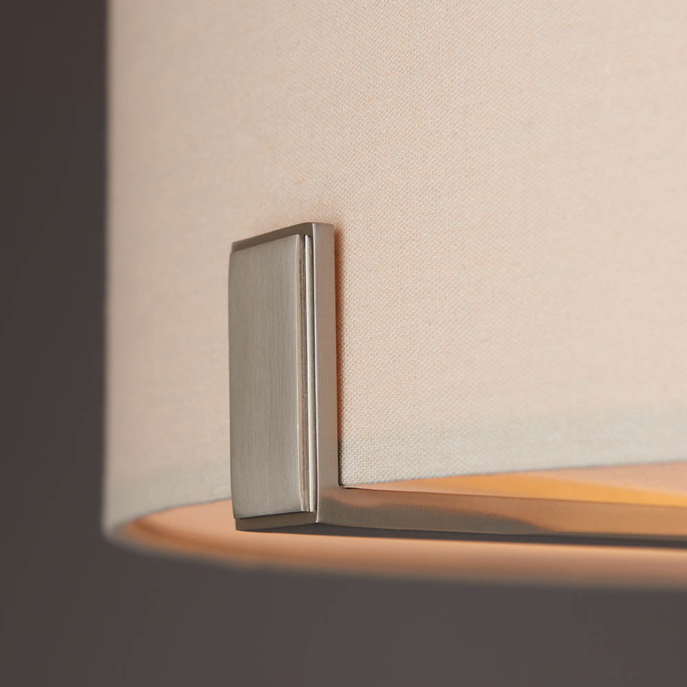 Close-up of the Endon Brendon 3 Light Pendant showing the brushed nickel bracket securing the pale grey fabric shade, with the diffuser softly lit inside.
