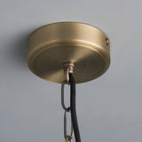 Close-up of the Endon Brenton pendant's brass ceiling rose with black fabric flex and chain suspension against a light grey ceiling.