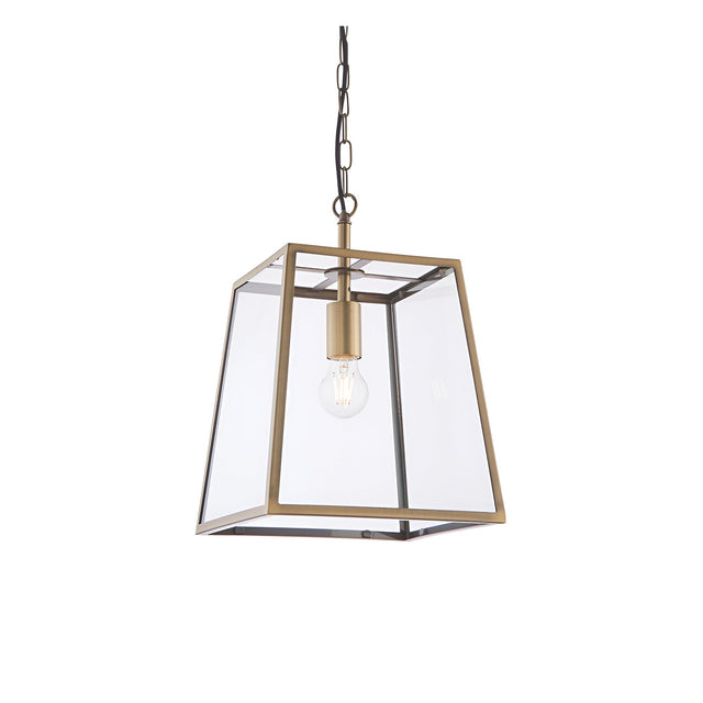 Endon Brenton lantern pendant in brass with tapered metal frame, clear glass panels and single E27 filament bulb, suspended from chain on white.