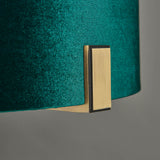Close-up of the Brendon Table Lamp's green velvet shade edge and matt antique brass bracket, on a plain grey background.