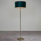 Endon Brendon floor lamp with slim antique brass stand, round base and green velvet cylinder shade, shown against a plain light background.