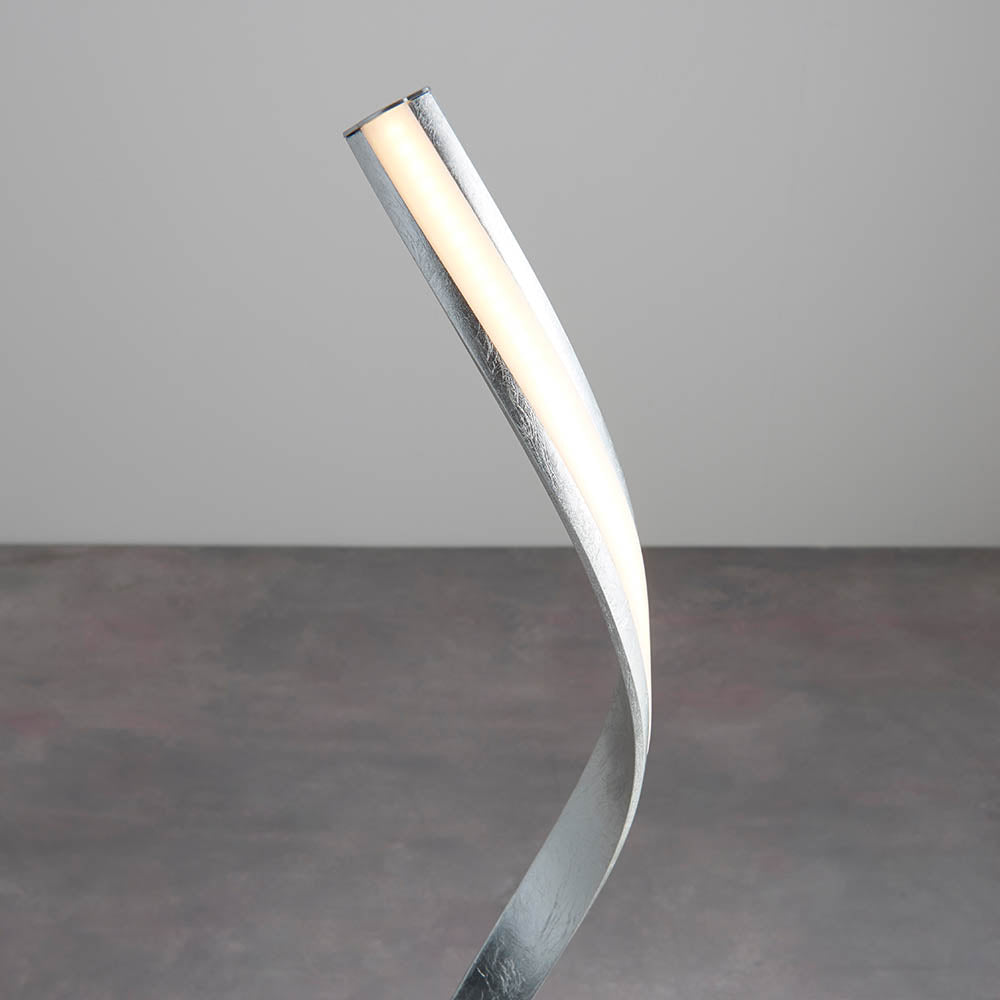 Endon Neve integrated LED floor lamp with a curved silver leaf frame and illuminated white diffuser, shown against a plain light grey background.