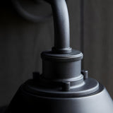 Close-up of the Caldton Outdoor Wall Light in matt black, showing the die-cast metal fitting with knurled detailing and curved arm.