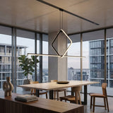 A modern dining room features a wooden table, four chairs, decorative vase, books, large potted plant, and city views. The Minimo LED Bar Square Linear Suspension Light in black adds minimalist elegance to the space.