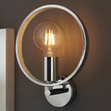 Endon Carlcombe chrome bathroom wall light with a circular faceted ring frame and single exposed E27 globe bulb, mounted beside a mirror.