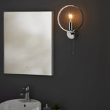 Endon Carlcombe chrome bathroom wall light with faceted ring, E27 globe bulb and pull cord, mounted beside a rectangular LED mirror above a basin.