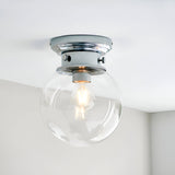Endon Tarn flush bathroom ceiling light in chrome with a clear glass globe shade and single E27 filament lamp, mounted to a white ceiling.