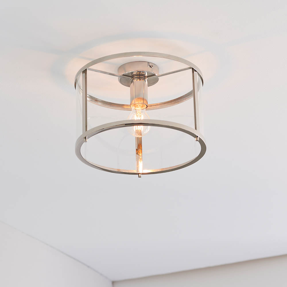 Endon Ellery flush ceiling light in brushed nickel with a drum-shaped glass shade and single E27 lamp, mounted on a white ceiling in a corner.