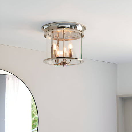 Endon Hollis 3 light flush ceiling light in nickel with cylindrical clear glass shade and three E14 candle lamps, mounted on a white ceiling.