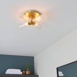 Endon Wren 4 light semi-flush bathroom ceiling light in brass with four ribbed glass shades on angled arms, mounted to a white bathroom ceiling.